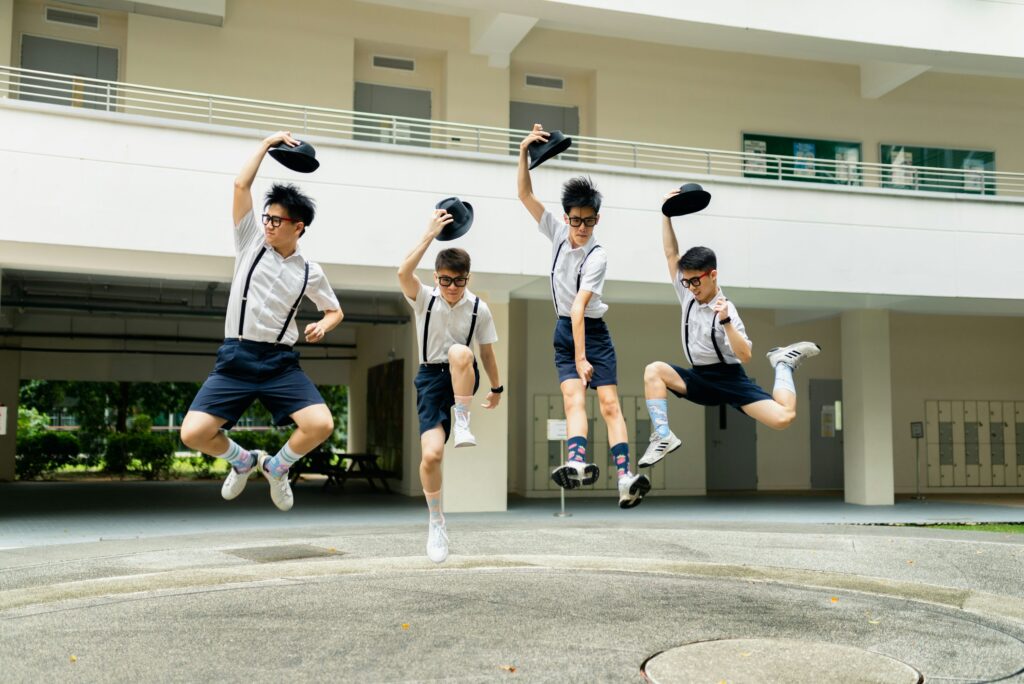 four men jumping on air beside building during daytime